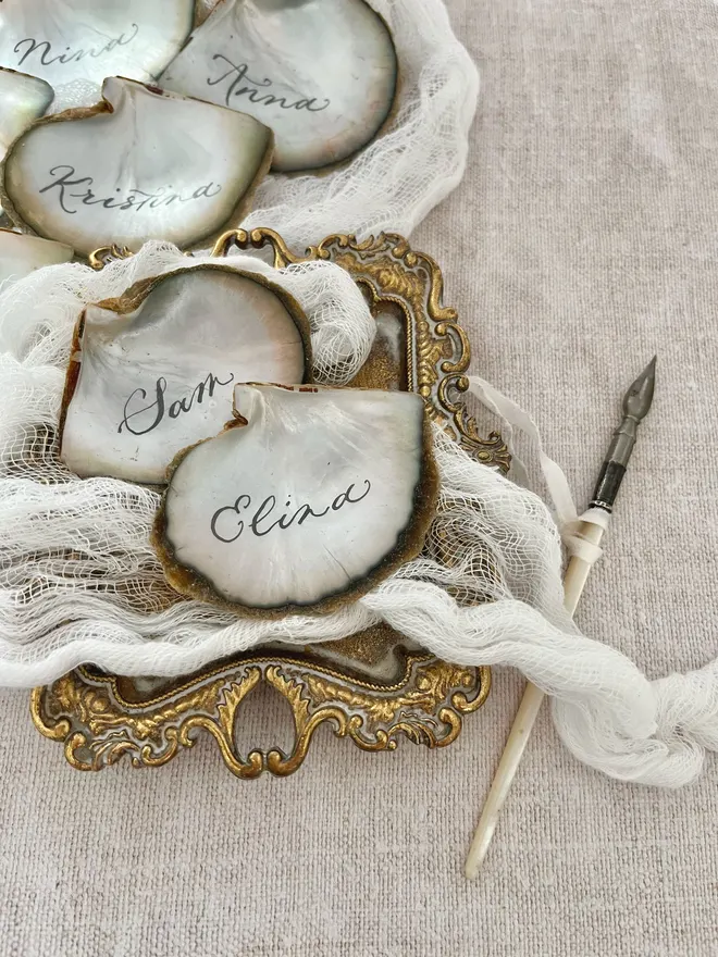 oyster shell place settings with guest names written in calligraphy