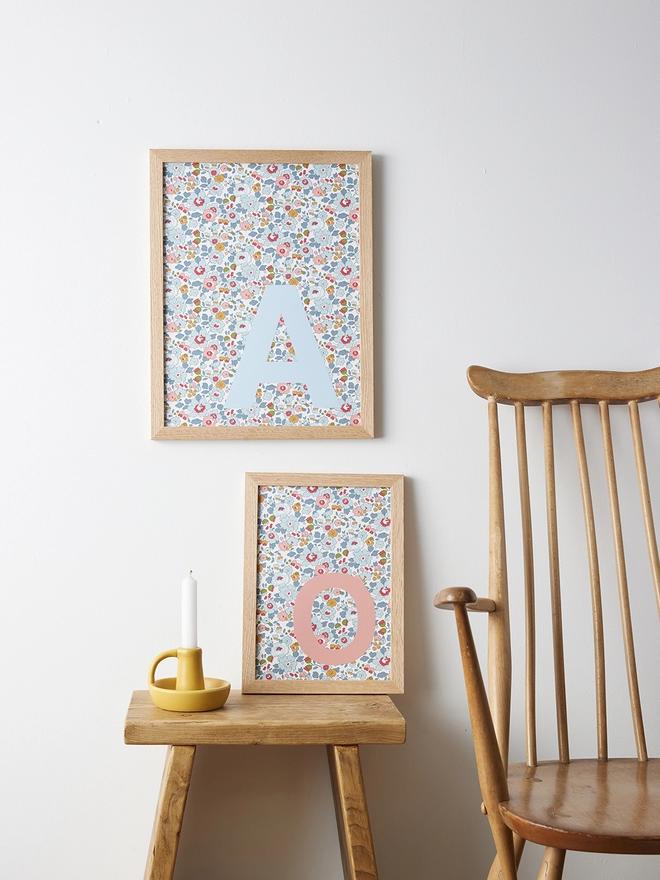 Personalised framed initials in pale blue and salmon pink on Liberty Betsy blue fabric