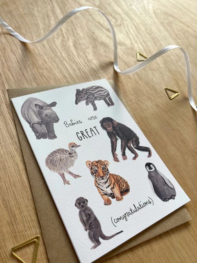 greetings card featuring seven baby animals (a rhino, a chimp, an ostrich, a meerkat, a tapir, a penguin and a tiger) with the phrase “babies are GREAT - congratulations”