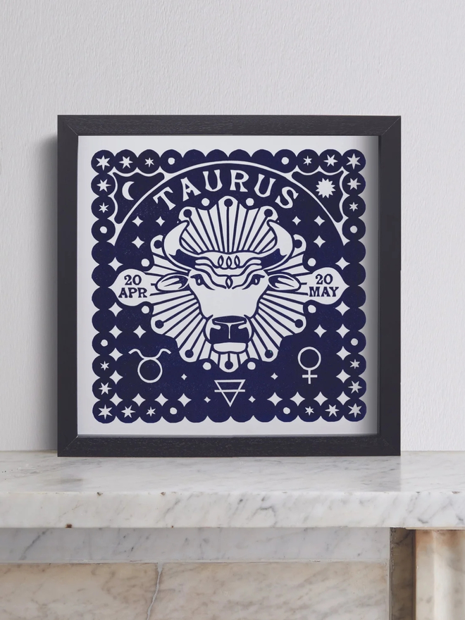 taurus zodiac linocut. a bull and zodiac symbols linocut and printed on a blue background.