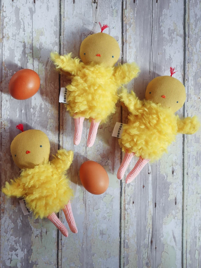 Yellow chick doll with linen head, fluffy faux fur body and orange stripe legs.
