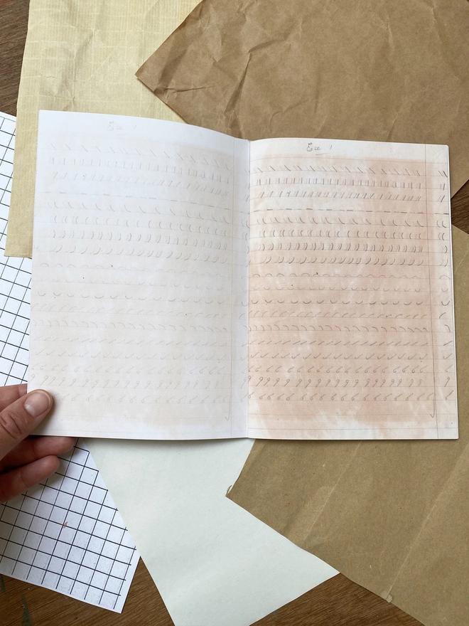 inside of Notebook on a desk with found paper around it.
