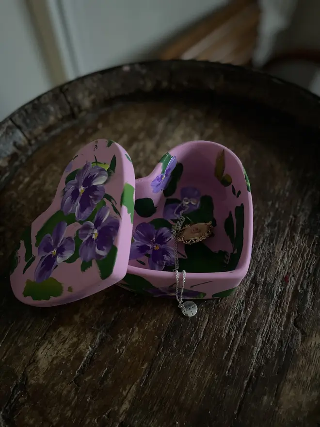 hand painted floral ceramic heart shaped keepsake box background in a pale pink with purple pansy flowers