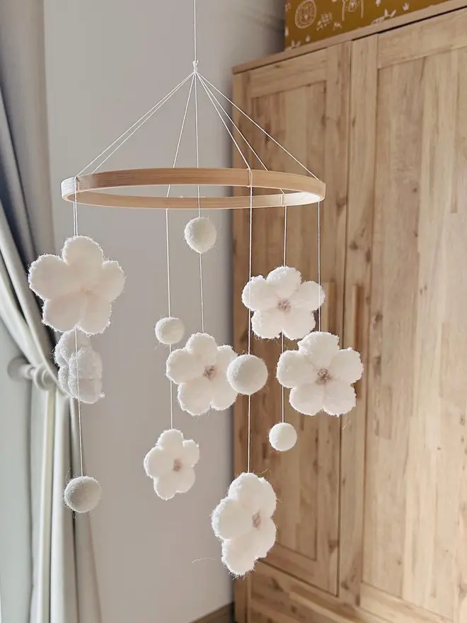 boucle flower baby mobile. a white cloth baby mobile hanging from the ceiling.