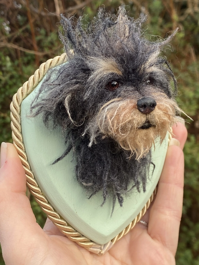 A custom needle-felted dog head on a custom colour wooden shield