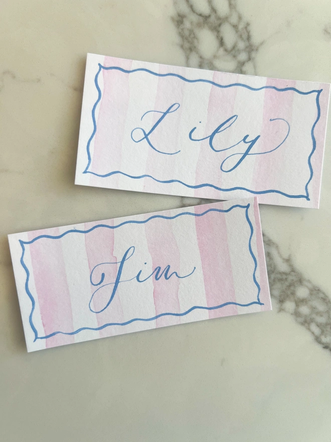 Personalised calligraphy event place cards, pink striped coloured place cards with blue calligraphy name
