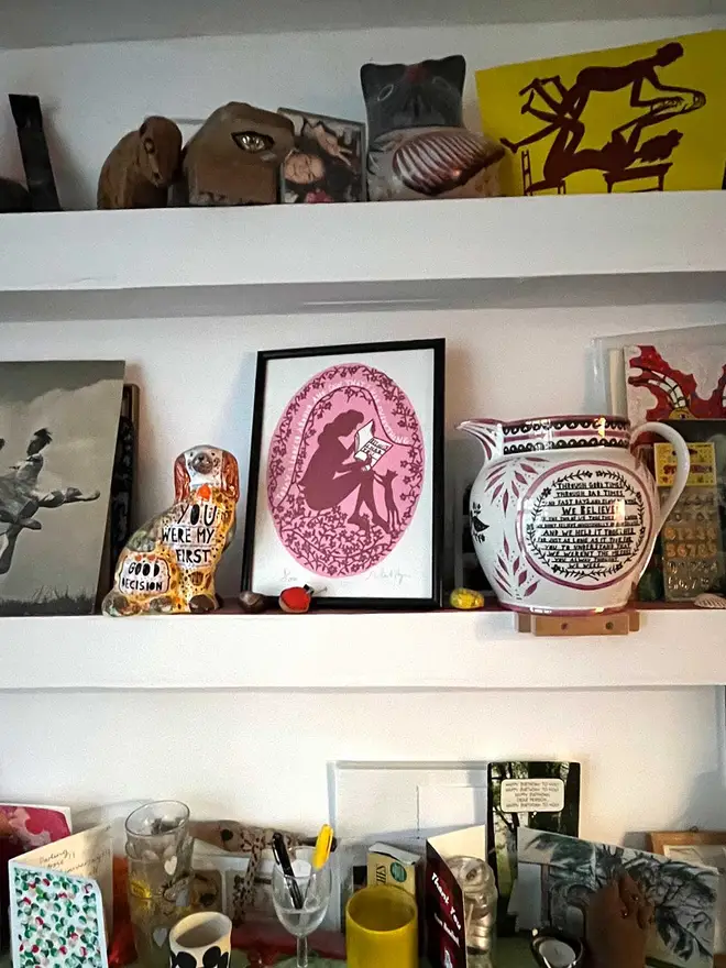 'I Had Everything Because I had You' screenprint in a black frame on a busy shelf