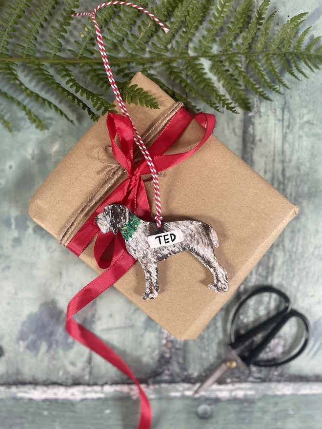 Italian Spinone Christmas Decoration placed on a wrapped Christmas gift