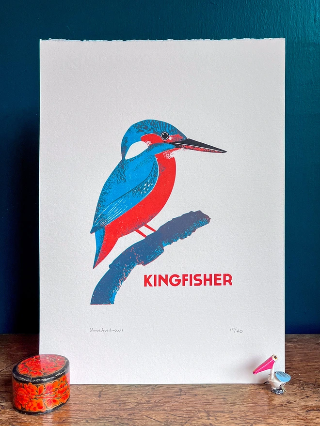 Illustrated Kingfisher print against a blue background