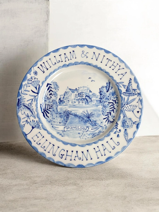 Medium wedding venue plate with couple's names over the top of the plate, the venue below and the date inset on a hand painted banner