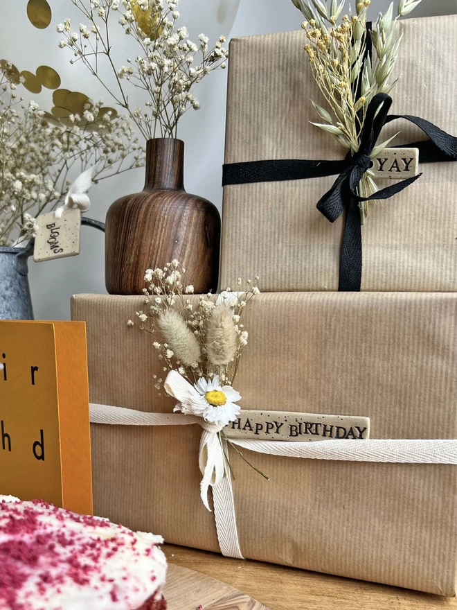 two brown wrapped parcels tied with cream and black ribbon and ceramic tags