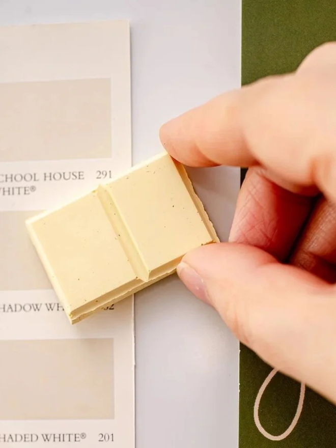 ceramic chocolate magets. a white chocolate magnet on a fridge door.