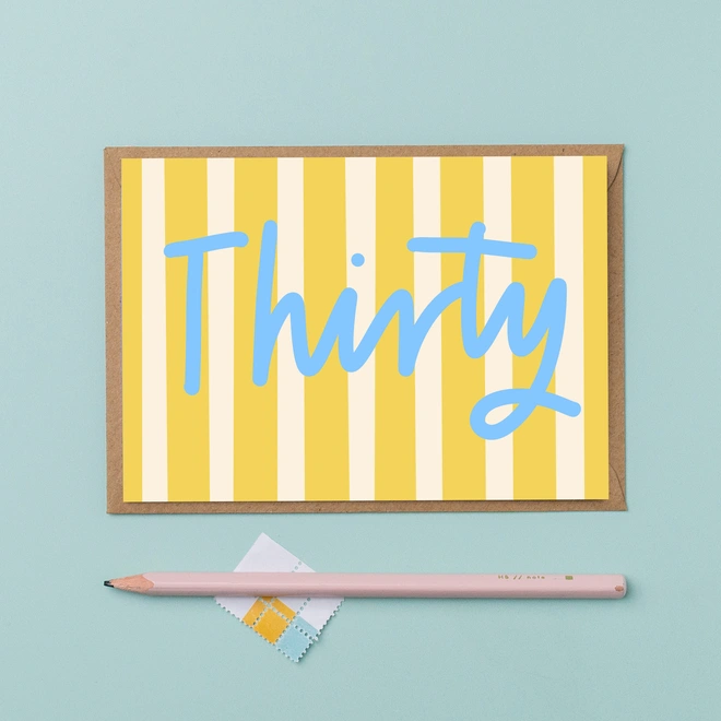 Thirtieth birthday card featuring the word thirty in a handwritten blue font on a yellow striped background,