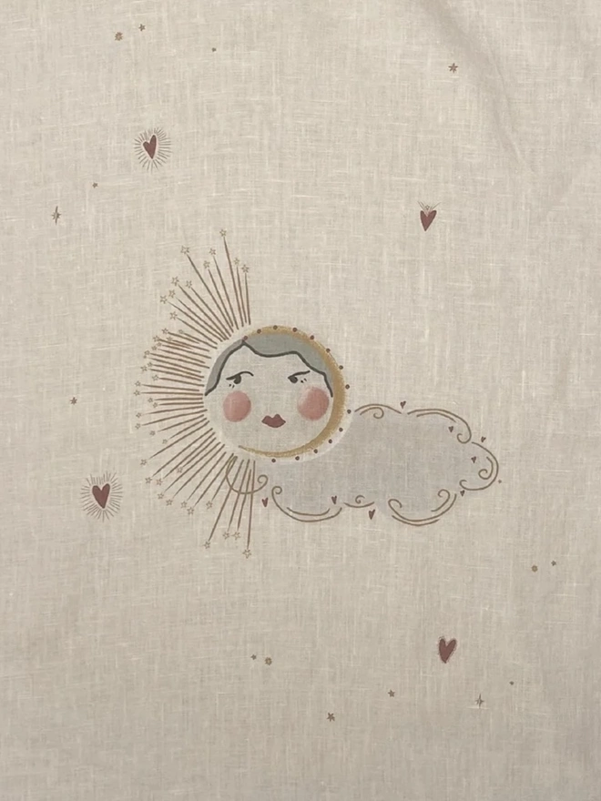 'Love Sun' Linen Tea Towel, a person holding up a linen tea towel with a sun motif on it. 