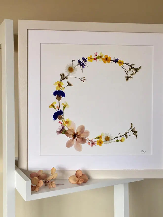 Pressed Wildflower Letter Print, a wildflower alphabet letter print sitting framed. 