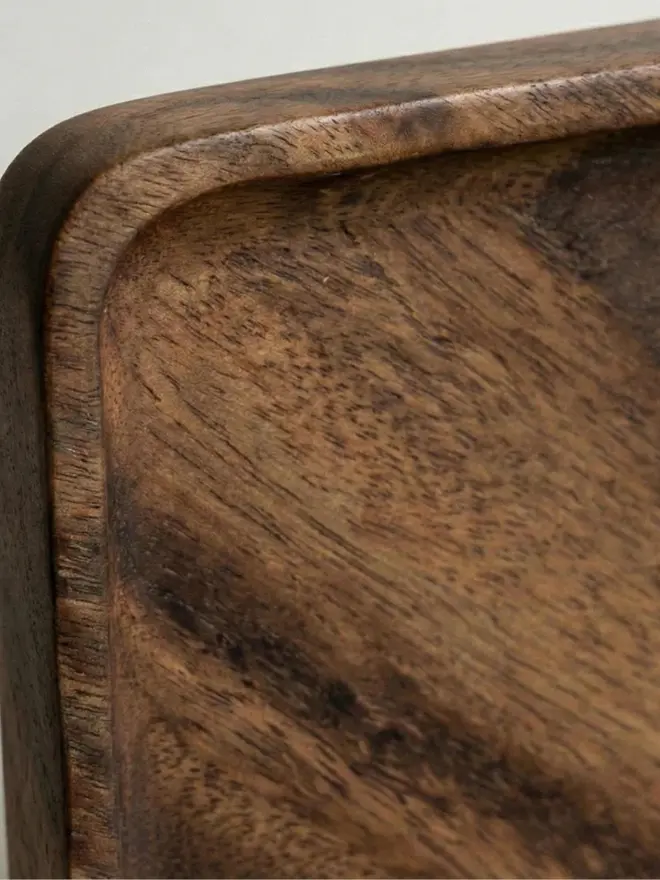 Zoom in on the Walnut Photobooth Frame For Photo Strip Prints, hanging on a white wall. 