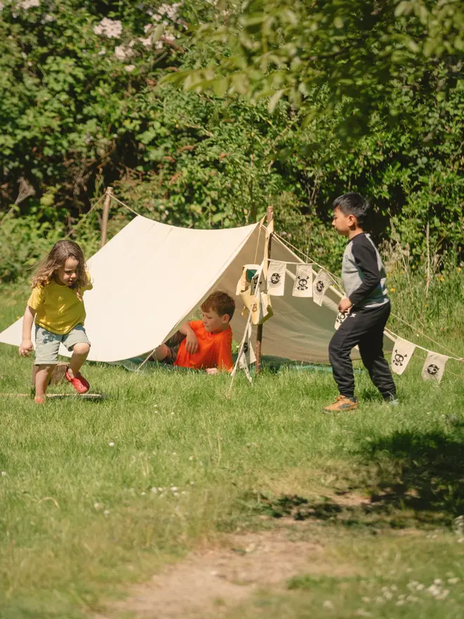 Children in a pirate den held up by wooden den poles
