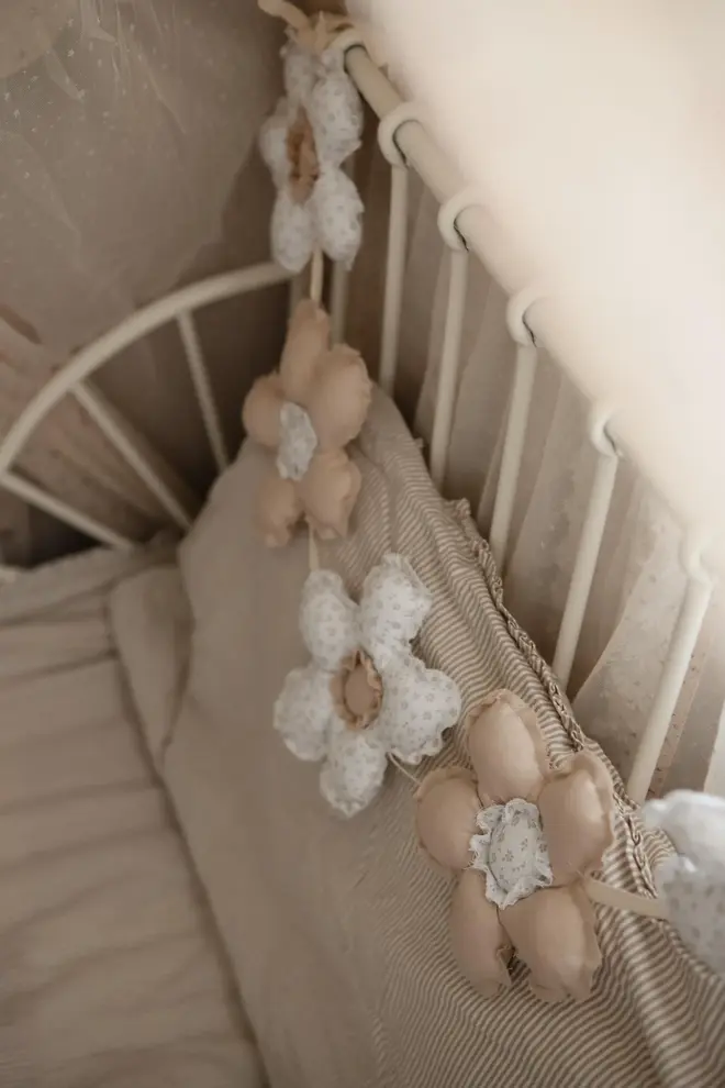 Daisy Flower Garland Decoration, a hanging colourful daisy flower garland sitting in a child's bedroom. 