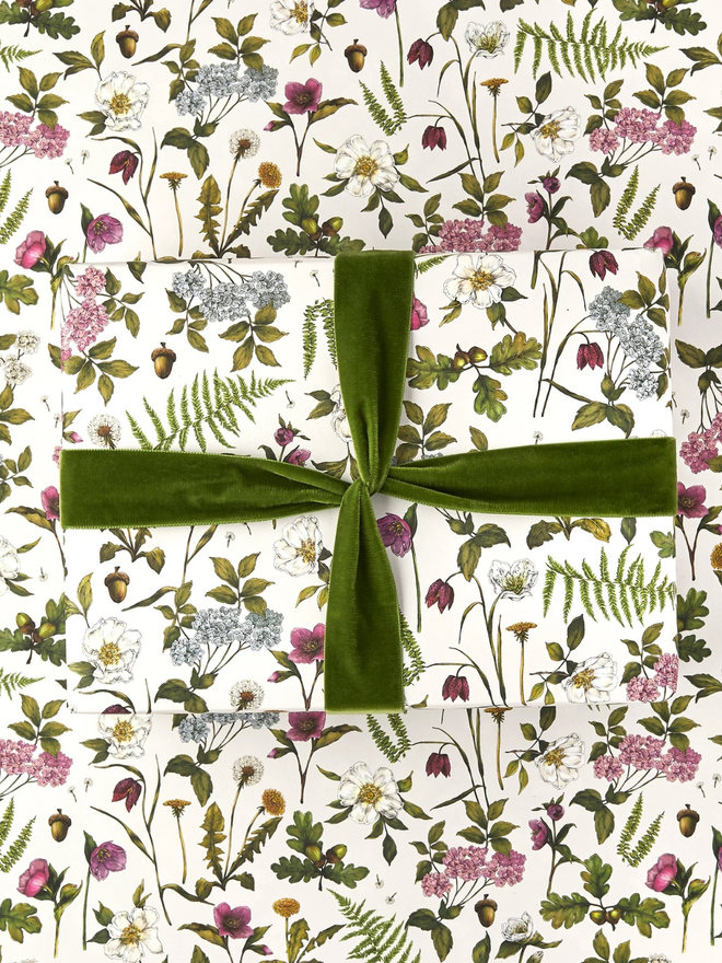 cottage garden floral gift wrap sheet. a box wrapped in multi-coloured illustrated floral gift wrap with a green ribbon.