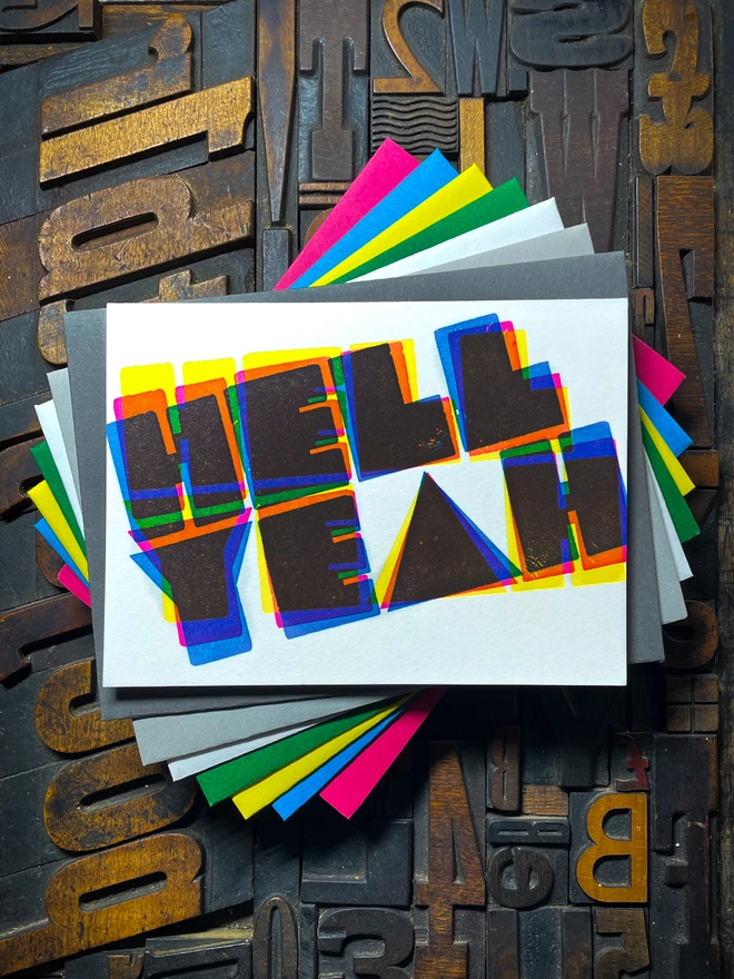 A congratulatory letterpress card using vibrant fluorescent inks the deep impression word HELL YEAH; in bold letters with a set of colourful envelopes. Perfect for exam results and graduations and other celebrations and milestones.