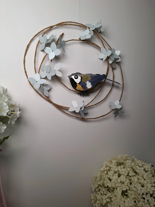 Floral wall art featuring a paper sculpture of a great tit