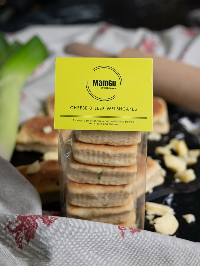 Package of cheese and Leek Welsh Cakes with a messy kitchen worktop in the background
