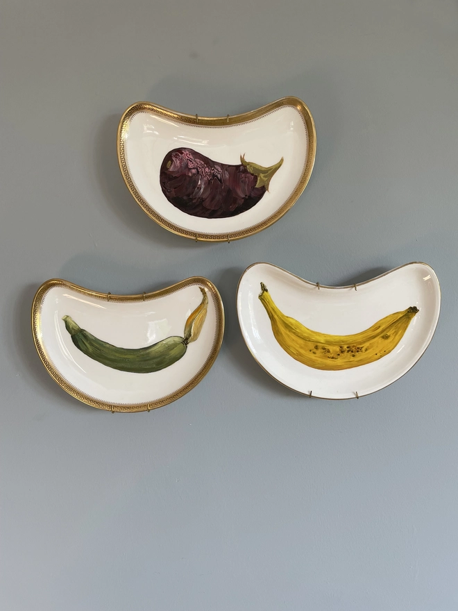 3 old painted plates on a wall