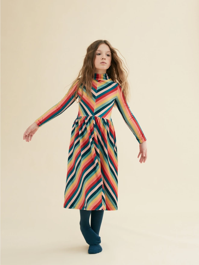 Dress made from a soft stretch velour in our own developed multi-stripe. Midi-length with a slim bodice and turtle neck. Featuring a mix of stripe directions detailing. Concealed zip to centre back.  