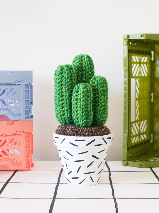 Green crocheted cactus in white and black hand-painted pot