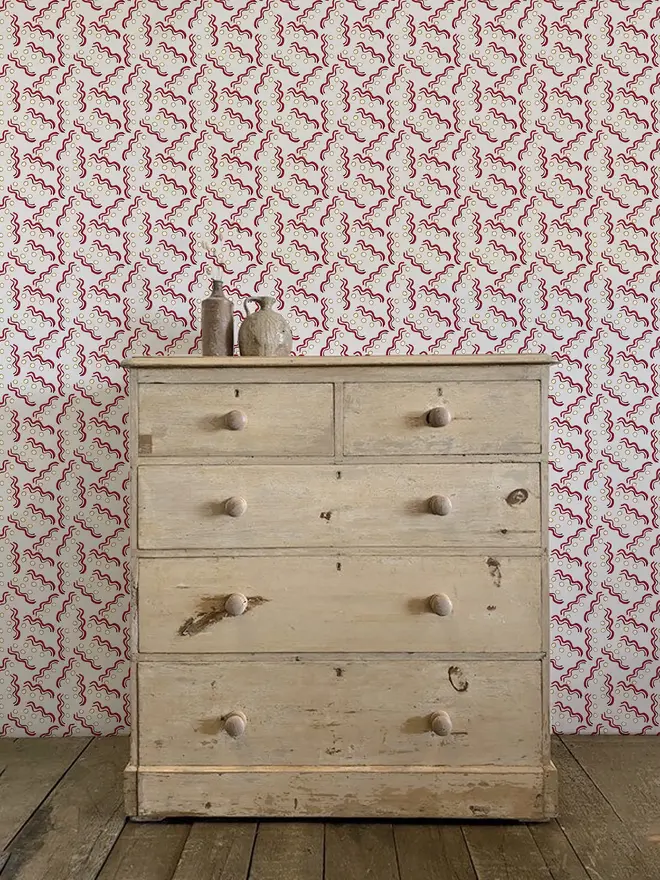 hoop and wiggle illustrated wall paper. a white background wallpaper patterned with red circles and squiggly lines.