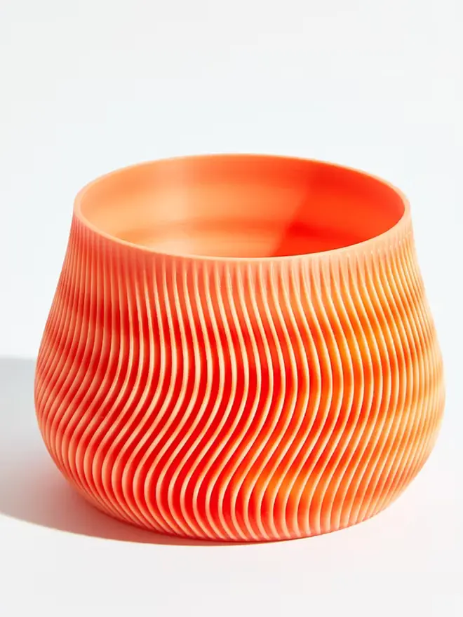 Sustainable 3D Printed Coral Orange Plant Pot, groovy design against a white background.
