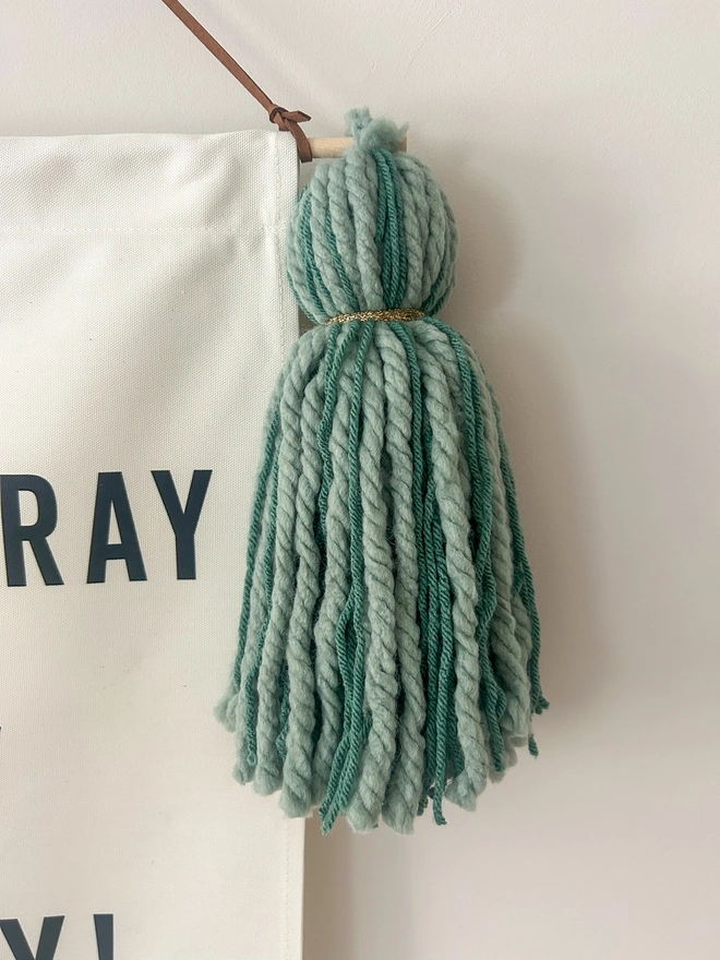 Large handmade green tassel on a fabric birthday banner