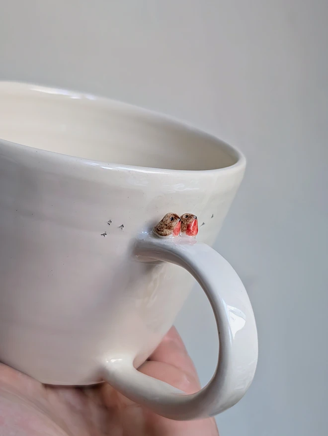 Robin couple cup with tiny robin birds on the handle of the white mug