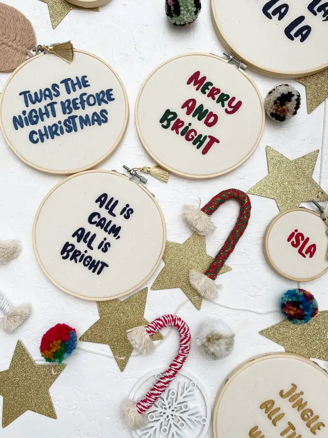 custom phrase embroidered christmas hoop. cotton hoop embroidered with assorted festive phrases.