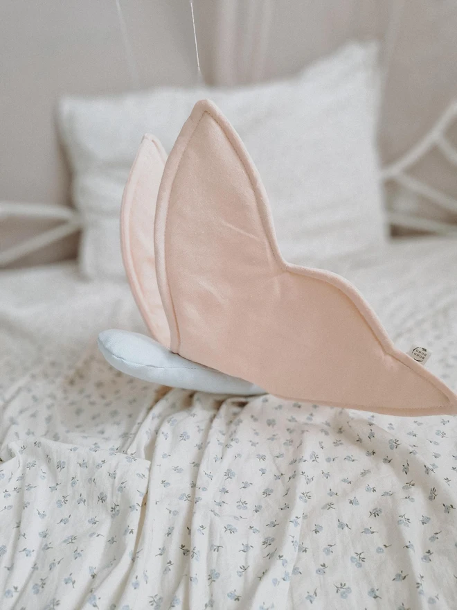 Butterfly Nursery Decoration, a colourful butterfly decoration sitting on a child's bed. 