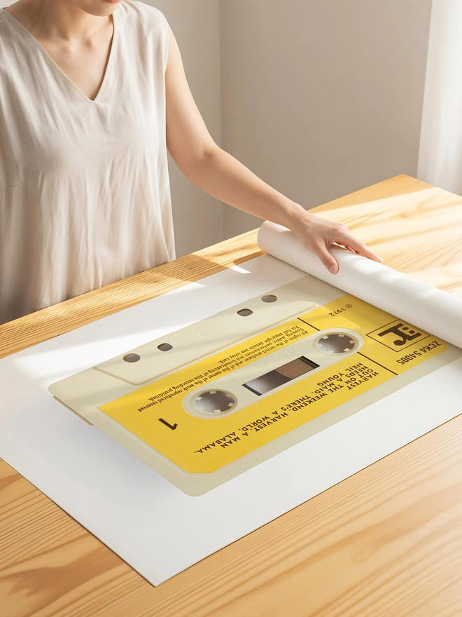 neil young harvest cassette tape print. print being unrolled on wooden table.