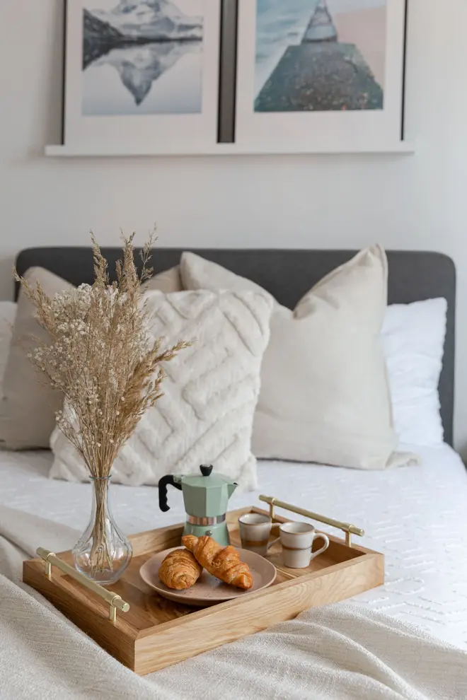 Oak and Brass Serving Tray, a wooden serving tray sat on a bed filled with food and drinks, accompanied by a vase. 