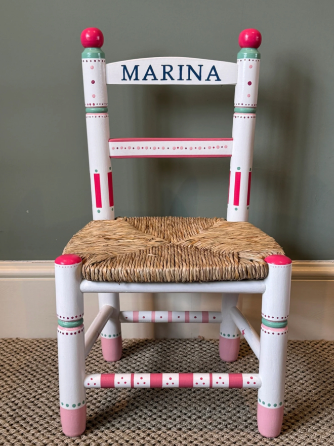 Marina Personalised Hand Painted Chair. A white chair with intricate red and green patterns.