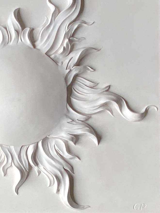 Detail of a plaster bas-relief sculpture of a solar eclipse