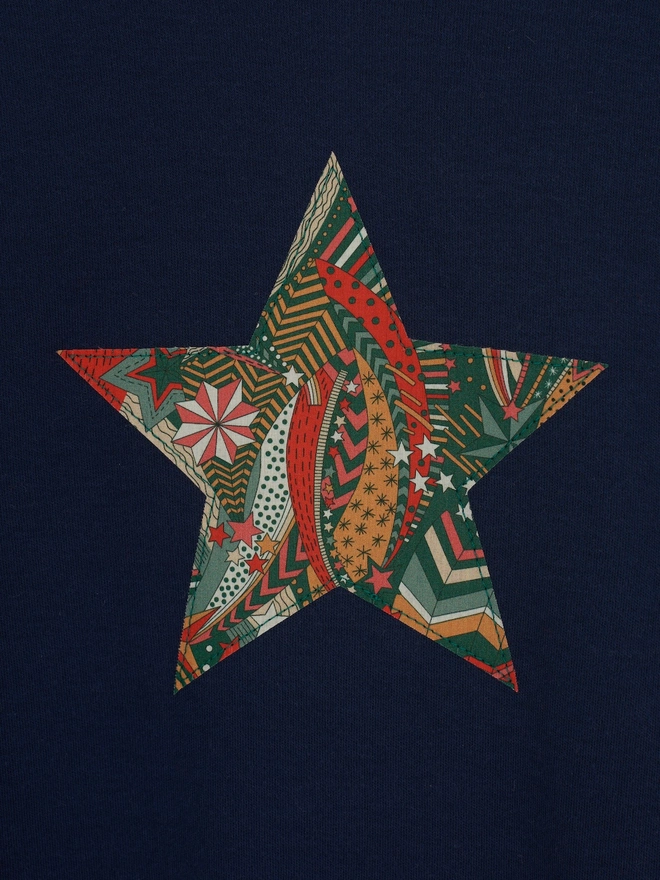 A navy christmas tee with a Liberty star print star sewn on the front, a close up of the appliqué stitching 