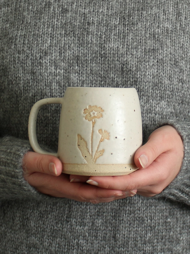Hands holding primrose mug