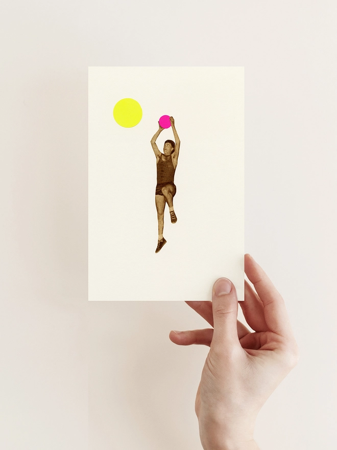 A greeting card depicting a male basketball player throwing a pink ball into the hoop.