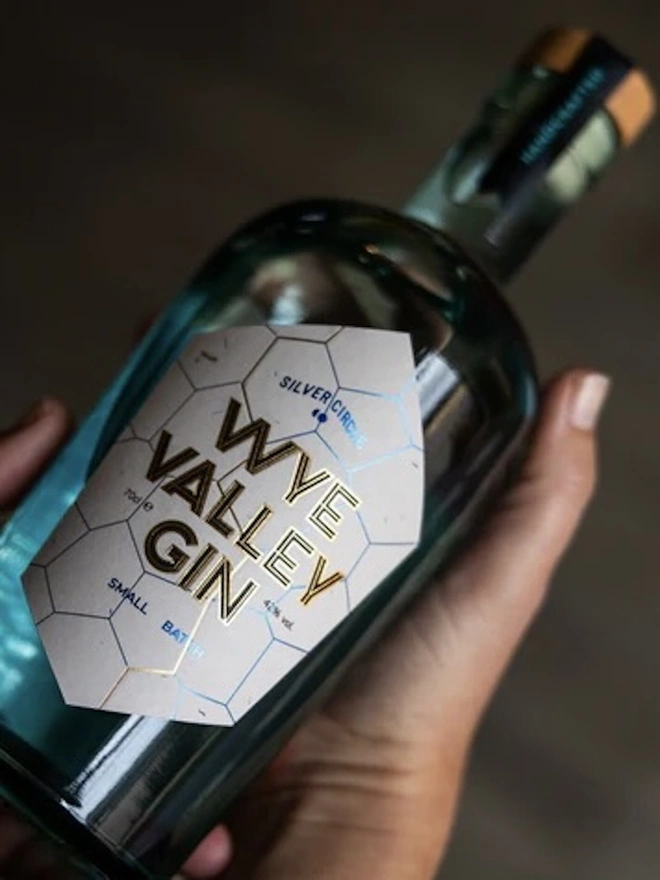 The Holiday Essentials Bundle (Pack Of 7), glass of spirit held by hand. 