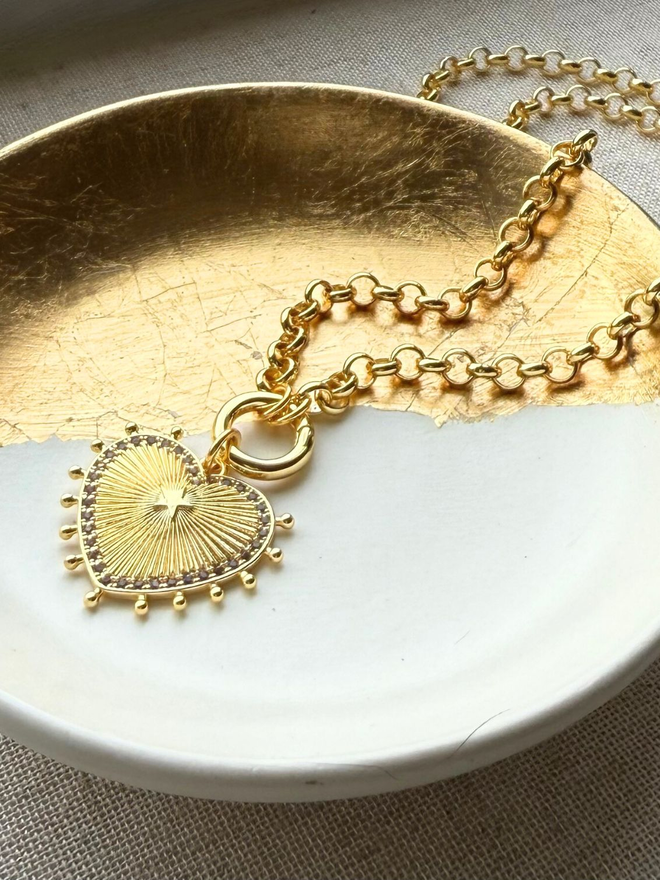 gold sunburst heart necklace on gold belcher chain