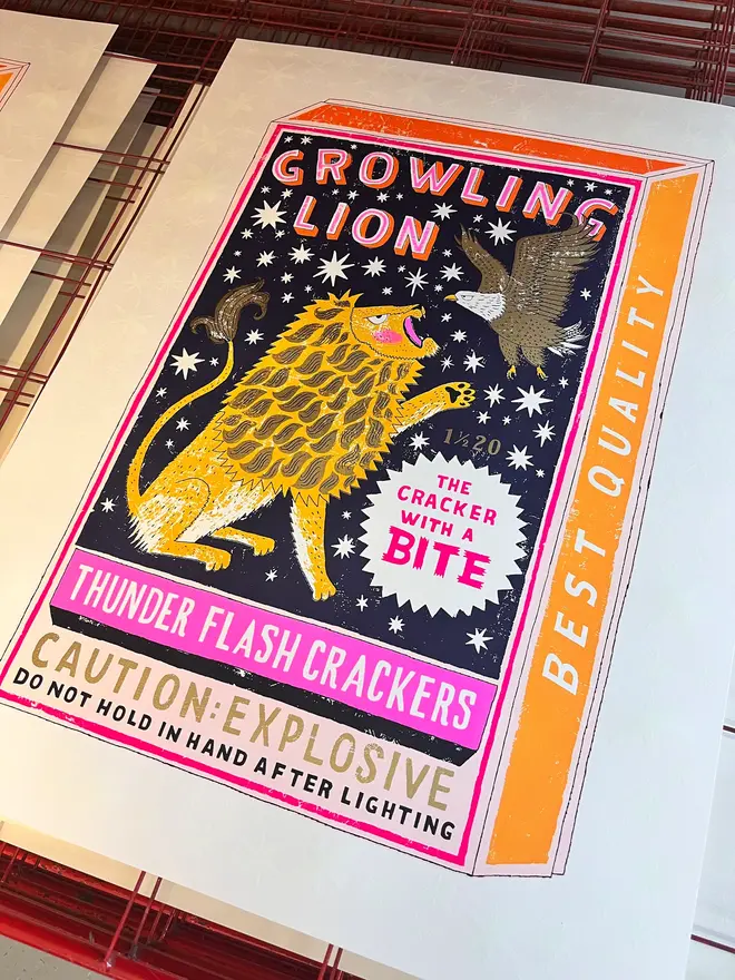 Lion And Eagle Firecracker Box Screenprint Late Night Bite, a colourful firecracker box design on a pale screenprint. It sits on a studio rack. 