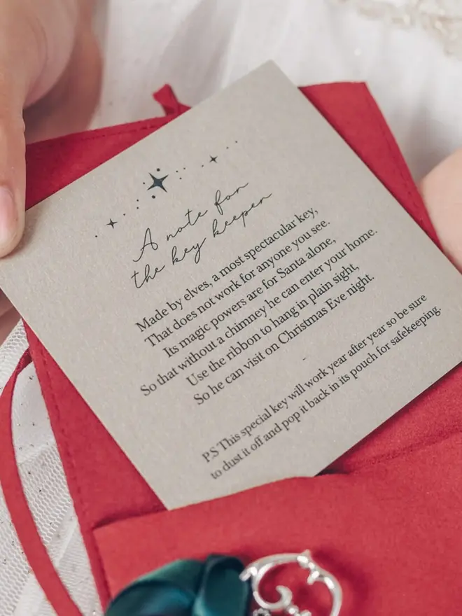 A "note for the key keeper" card rests on a red suede pouch. The poem explains the key lets Santa visit homes without a chimney.