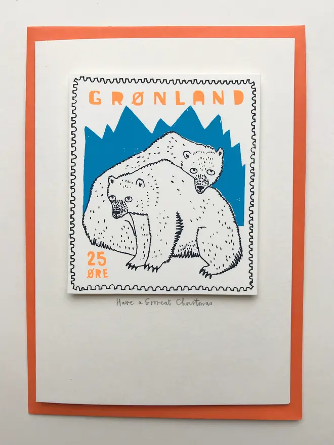 Polar Bear Have A Grrreat Christmas Card, a white card with a colourful polar bear design in the centre on top of an orange envelope on a plain white surface. 