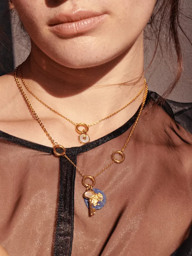 Woman wearing gold necklaces with charms and pendants