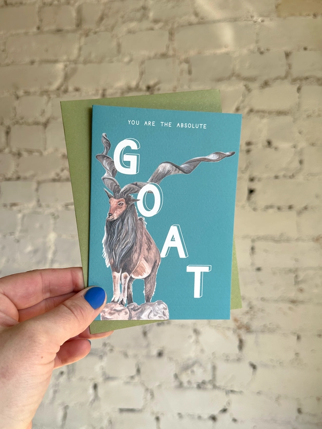 A strong turquoise card featuring a realistic illustration of a markor goat and the text "You Are The Absolute GOAT" with a green envelope
