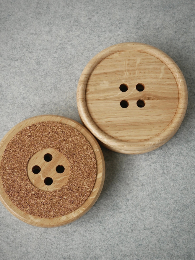 Wooden Button Drink Coaster. A bird’s eye view of two coasters. One is flipped upside down to show the soft underneath.